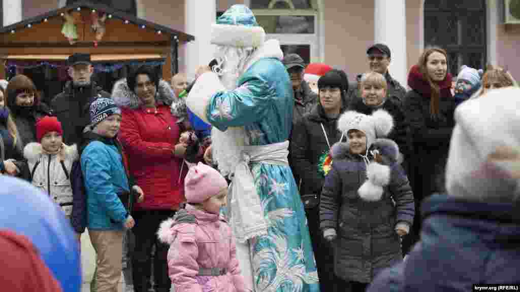 Ведущий в костюме Деда Мороза играет с детьми